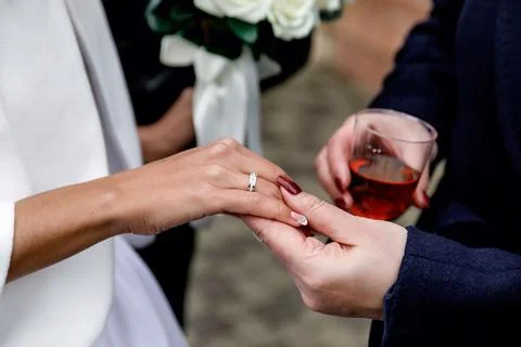 The groom puts the ring on the bride's hand Stock Photos