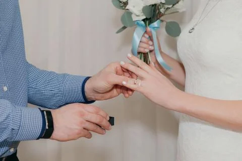 The groom puts the second ring on the brides finger at the wedding ceremony Stock Photos