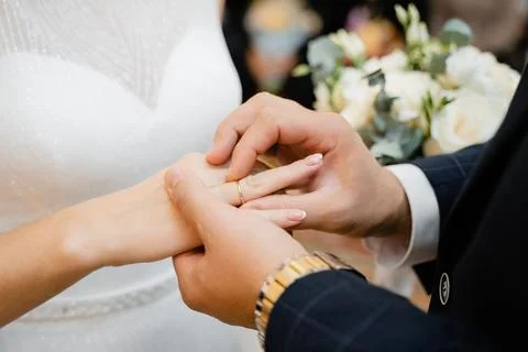 Groom puts wedding ring on bride Stock Photos