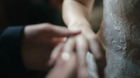 The groom puts the wedding ring on finger of the bride. marriage hands with Stock Footage 87568182