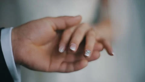 The groom puts the wedding ring on finger of the bride. marriage hands with Stock Footage