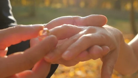 The groom puts the wedding ring on finger of the bride. marriage hands with Stock Footage