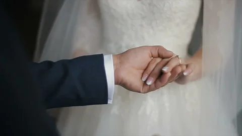The groom puts the wedding ring on finger of the bride. marriage hands with Video stock 102428488