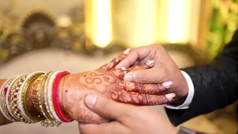 Groom Putting Engagement Ring on Bride's Henna Hand Stock Footage 341879077