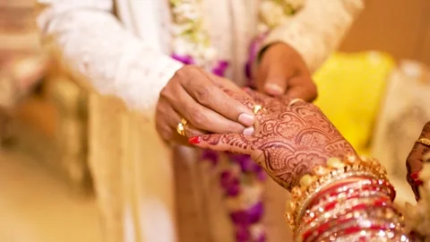 Groom Putting Ring on Bride's Henna-Decorated Hand Stock Footage 342097693