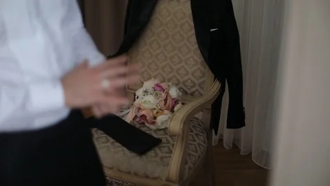 Groom is putting the ring on the finger on the background of flowers Stock Footage 98587432