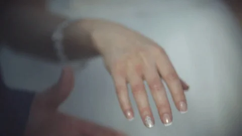 Groom putting a wedding ring on bride's finger 動画素材 76810108