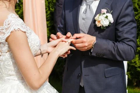 Groom putting a wedding ring on bride's finger Stock Photos