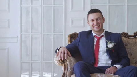 Groom sits on a sofa Stock Footage 73290275