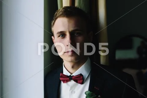 Groom standing at the window Stock Photos
