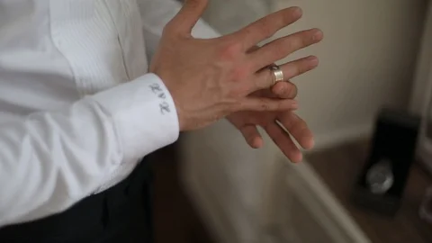 Groom is taking the ring and putting the ring on the finger Stock Footage 98587114