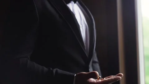 Groom throws up and holding wedding rings close up several times. Slow motion Stock Footage 243315947