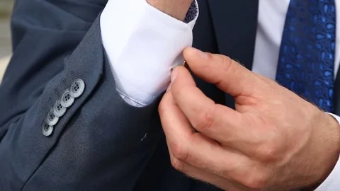 Groom wears and corrects cufflinks Stock Footage 73076953
