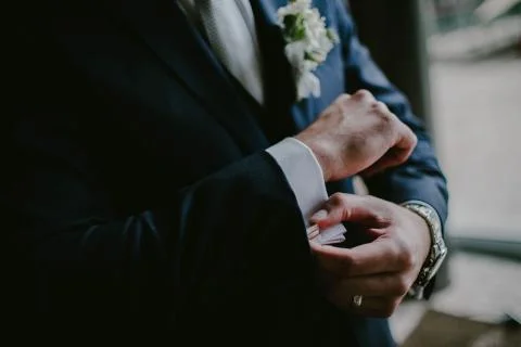 The groom wears cufflinks Stock Photos