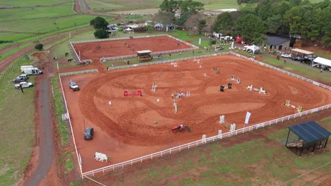 A grooming machine levels the red sand in the arena ahead of equestrian Stock Footage 310280442