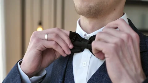 The groom's hand tying a tie by the window before the wedding ceremony. Stock Footage 309700995