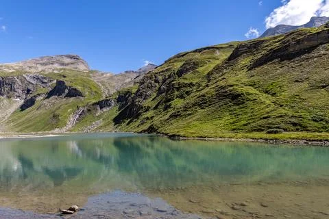 Grossglockner mountain range in Austria with green grass and lake in foregrou Stock Photos