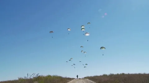 Ground angle view of paratroopers parachuting to earth from a C-17. Stock Footage 74796758