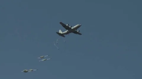 Ground angle view of paratroopers parachuting to earth from a C-17. Stock Footage 74798582