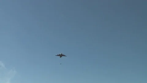 Ground angle view of paratroopers parachuting to earth from a C-17. Stock Footage 74799893