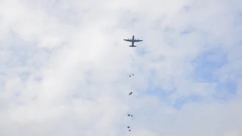 Ground angle view of paratroopers parachuting to earth from a C-17. Stockbeeldmateriaal 74809876