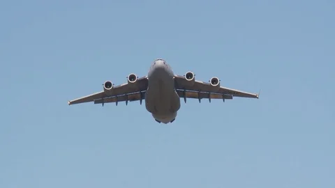 Ground angle view of paratroopers parachuting to earth from a C-17. Stock Footage 74812679