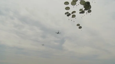 Ground angle view of supplies airdropped and parachuting to earth from a C-17. Видео 123374489
