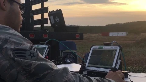 Ground based controller viewing imagery captured by drone on computer screen Stock Footage 98236529