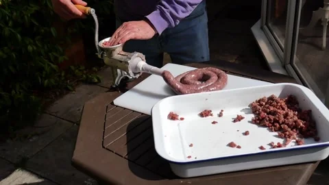 Ground beef being manually filled into sausage casing Stock Footage 305654576