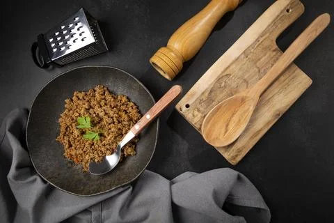 Ground beef in dark plate on the table. Stock Photos