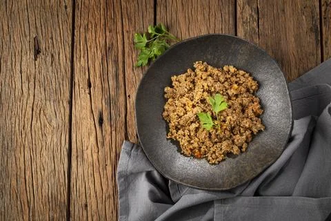 Ground beef in dark plate on the table. Stock Photos