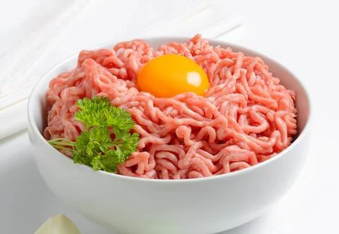 Ground beef with egg and parsley in bowl Stock Photos