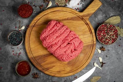 Ground beef. Fresh raw beef minced meat on dark background. Butcher products. Stock Photos