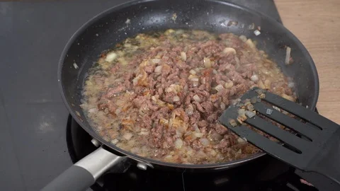 Ground beef fried with onions in a black pan Stock Footage 130002637