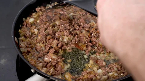 Ground beef fried with onions in a black pan Stock Footage 130010428