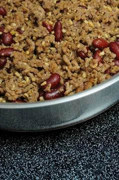 Ground beef hamburger meat mixed in with dark red kidney beans cooking in a s Stock Photos