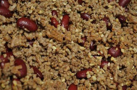 Ground beef hamburger meat mixed in with dark red kidney beans cooking in a s Stock Photos