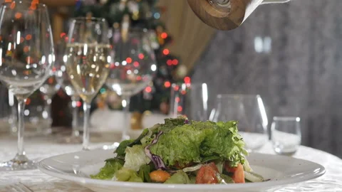Ground black pepper from spinning pepper mill falling on salad in slow motion Stock Footage 121020798