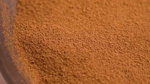 Ground chicory powder falling into a rotating eco friendly wooden bowl Stock Footage 306685039