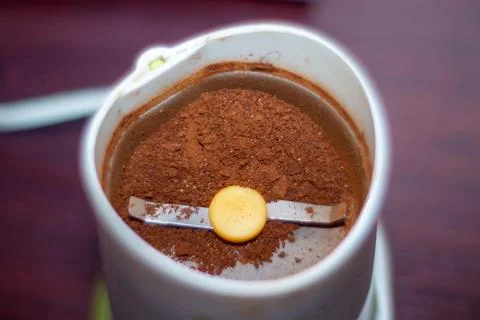 Ground coffee beans inside electric grinder for brewing delicious beverage 스톡 사진