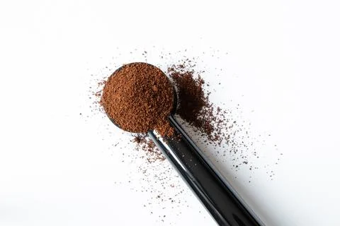 Ground coffee in a measuring spoon on a white background, coffee Stock Photos