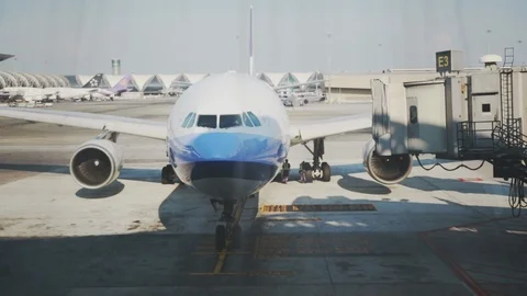 Ground crew attaching Jetbridge to an arriving plane Video stock 107037372