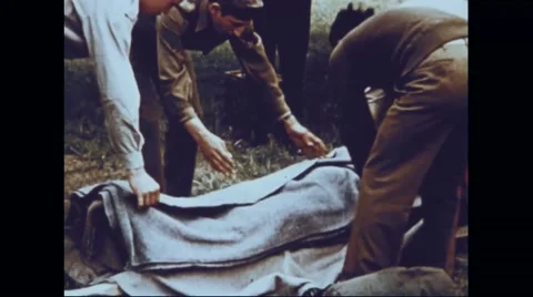 Ground crew covering injured bombardier with blanket Stock Footage