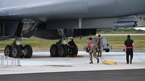Ground crew placing wheel chocks under B-1B Lancer's landing gear Stock Footage 300260968