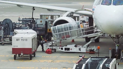 Ground Crew Using Conveyor Belt to Unload Baggage from Plane in Changi Airpor 库存影片 74625928