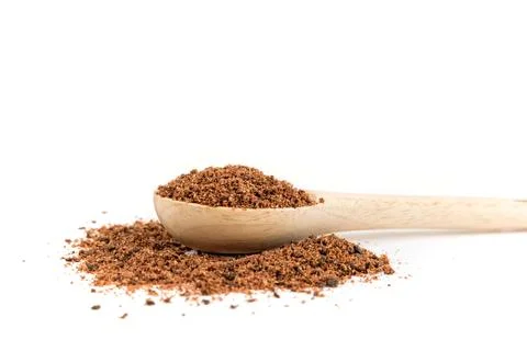 Ground dried sumac berry powder in a wood measuring spoon side view close up Stock Photos