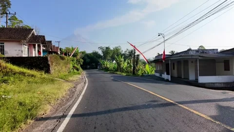 Ground Level Curving Road Through Tropical Village Houses Видео 345154387