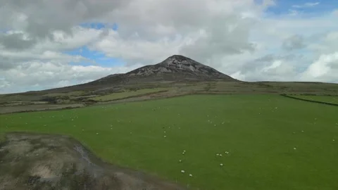 Ground level to elevated position across farmland looking toward mountain 스톡 동영상 155762827