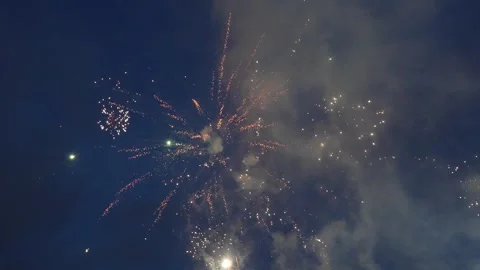 Ground Level Fireworks Bursting Across Smoky Night Sky Видео 345835058