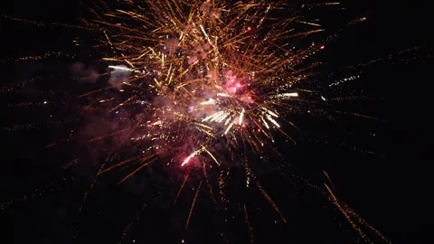 Ground-level footage of fireworks exploding in the night, capturing festive Stockbeeldmateriaal 327778494
